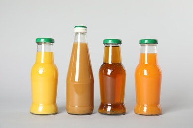 Bottles with different drinks on color background