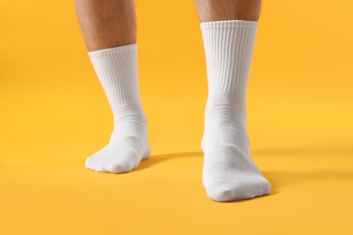 Photo of Man in stylish white socks on yellow background, closeup