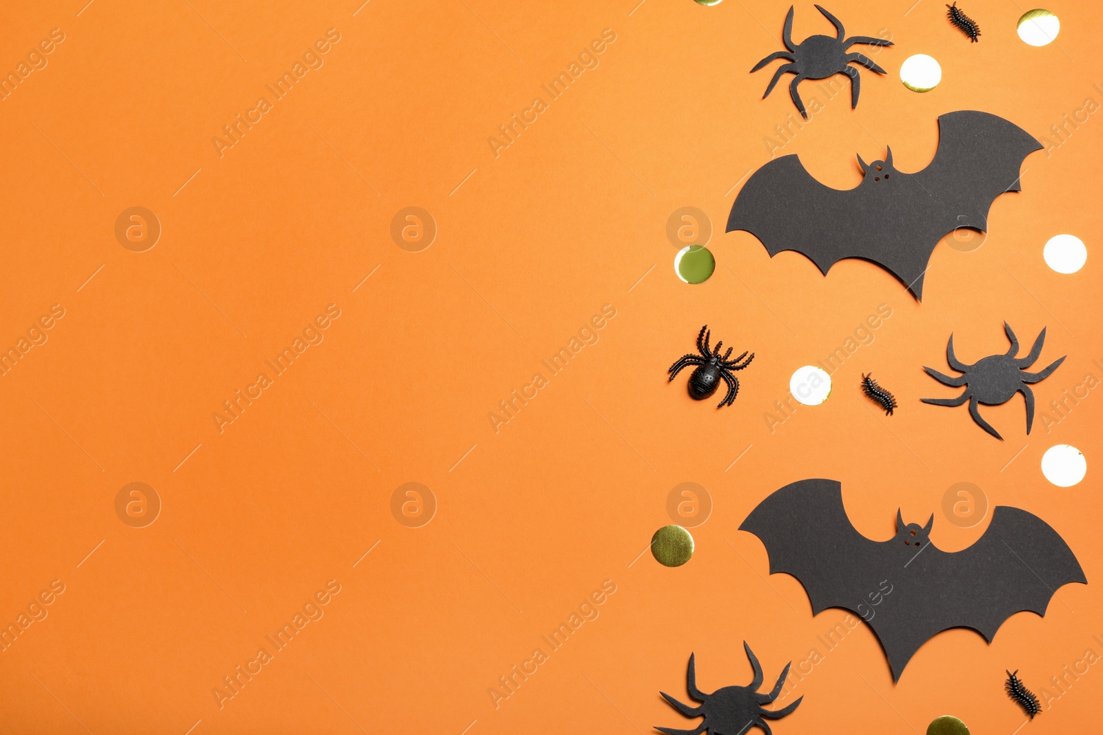 Photo of Flat lay composition with paper bats and spiders on orange background, space for text. Halloween decor