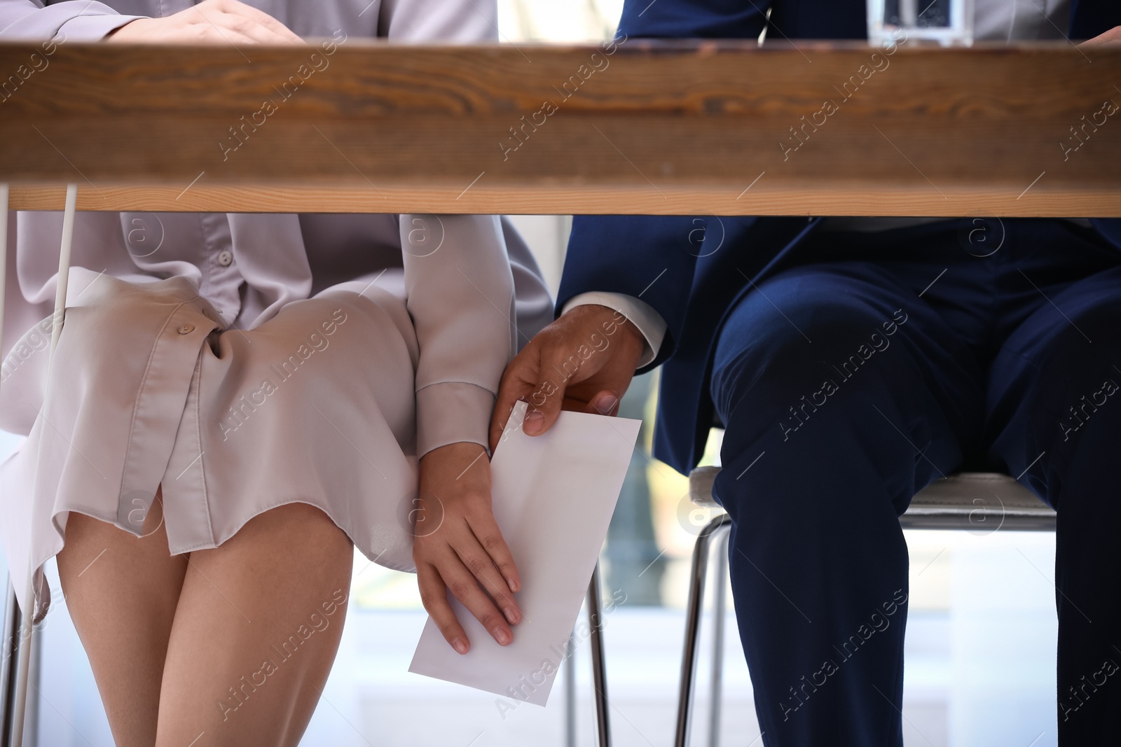 Photo of Man giving bribe money under table indoors, closeup