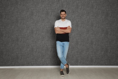 Photo of Full length portrait of handsome man against grey wall