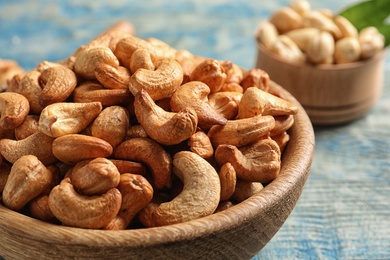 Tasty cashew nuts in bowl on table, closeup