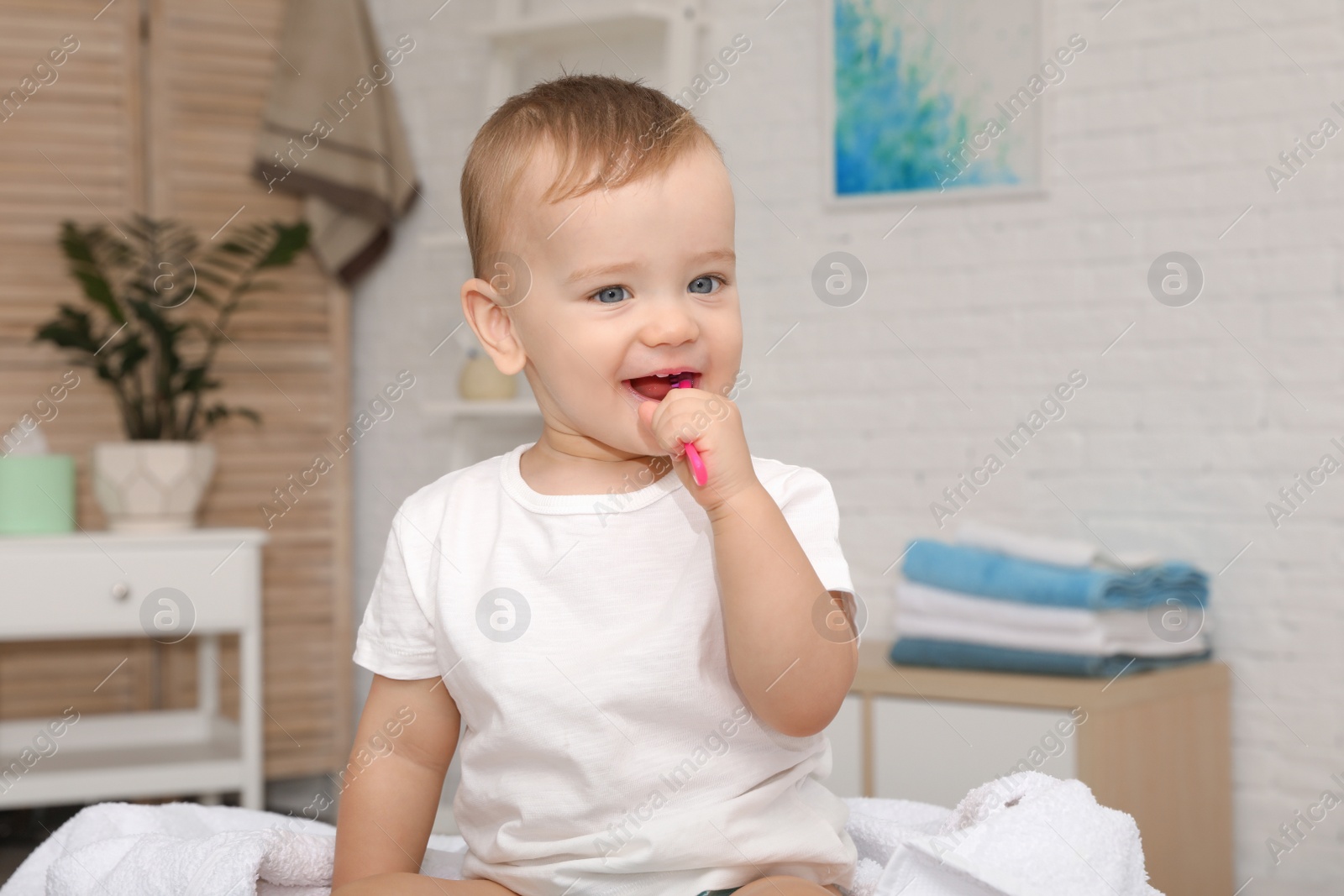 Photo of Cute little boy with toothbrush on blurred background