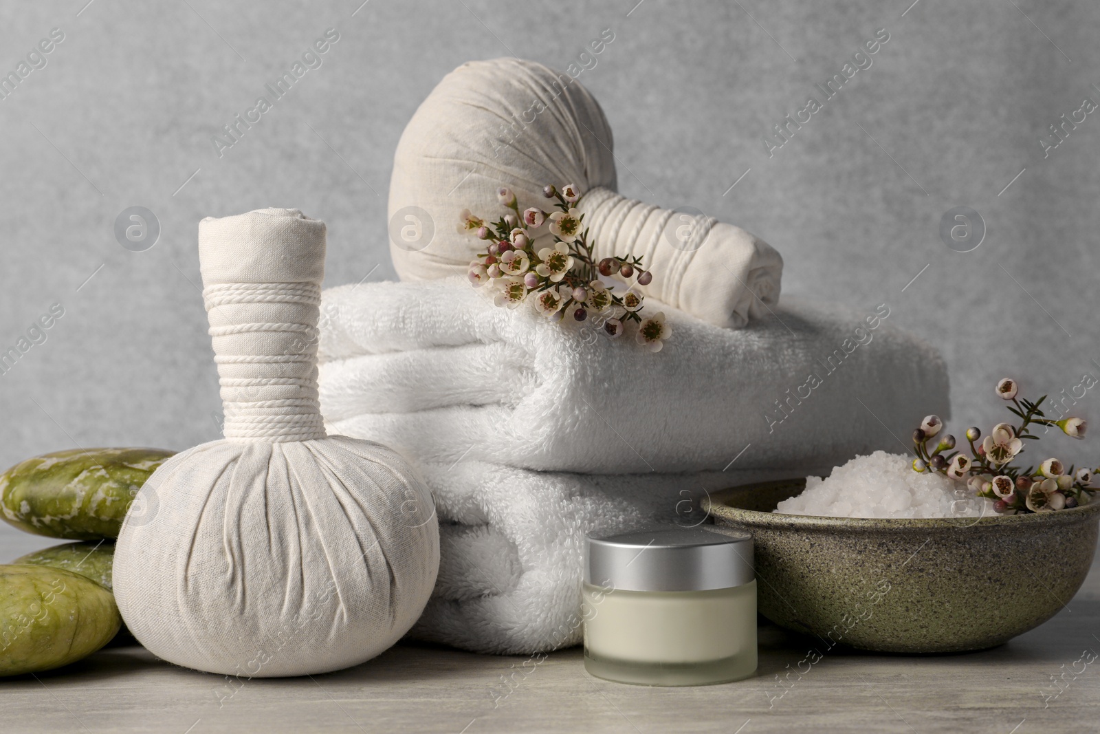 Photo of Composition with spa products and flowers on grey wooden table