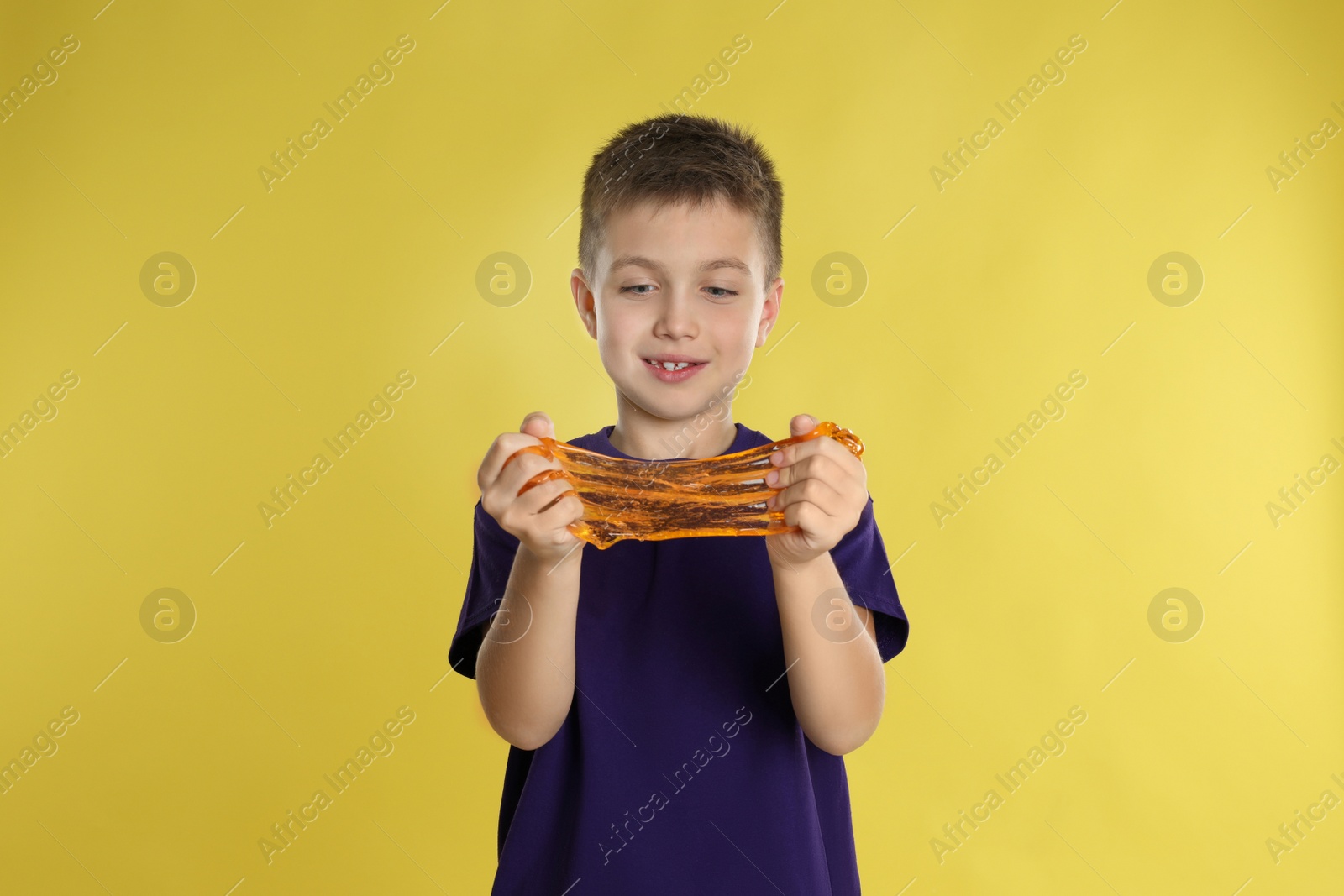 Photo of Little boy with slime on yellow background