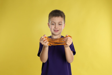 Photo of Little boy with slime on yellow background