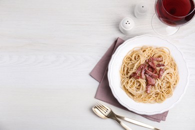 Photo of Delicious Carbonara pasta served on white wooden table, flat lay. Space for text