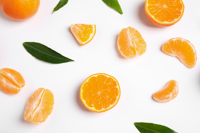 Photo of Composition with fresh ripe tangerines and leaves on white background, flat lay. Citrus fruit