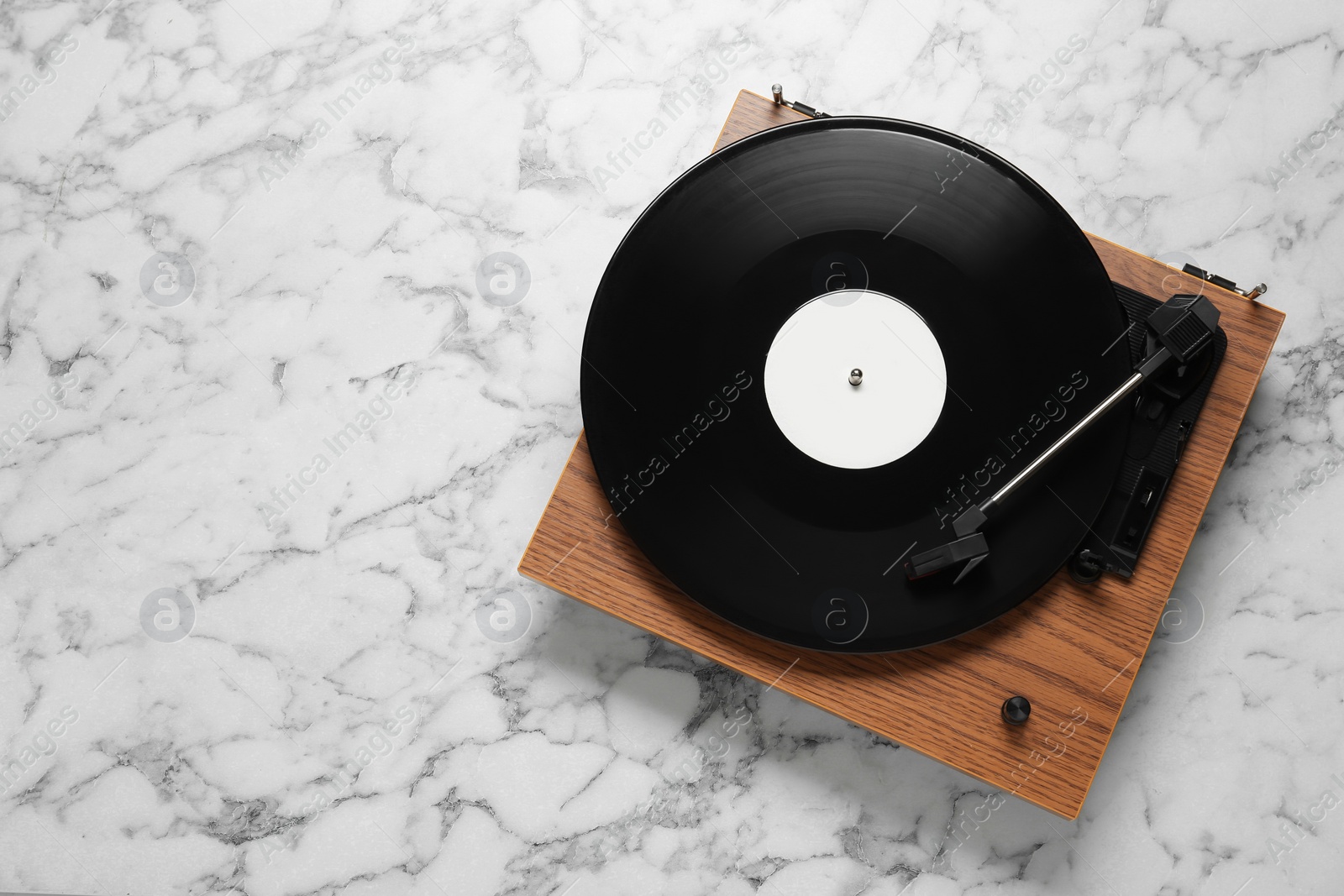 Photo of Turntable with vinyl record on white marble background, top view. Space for text