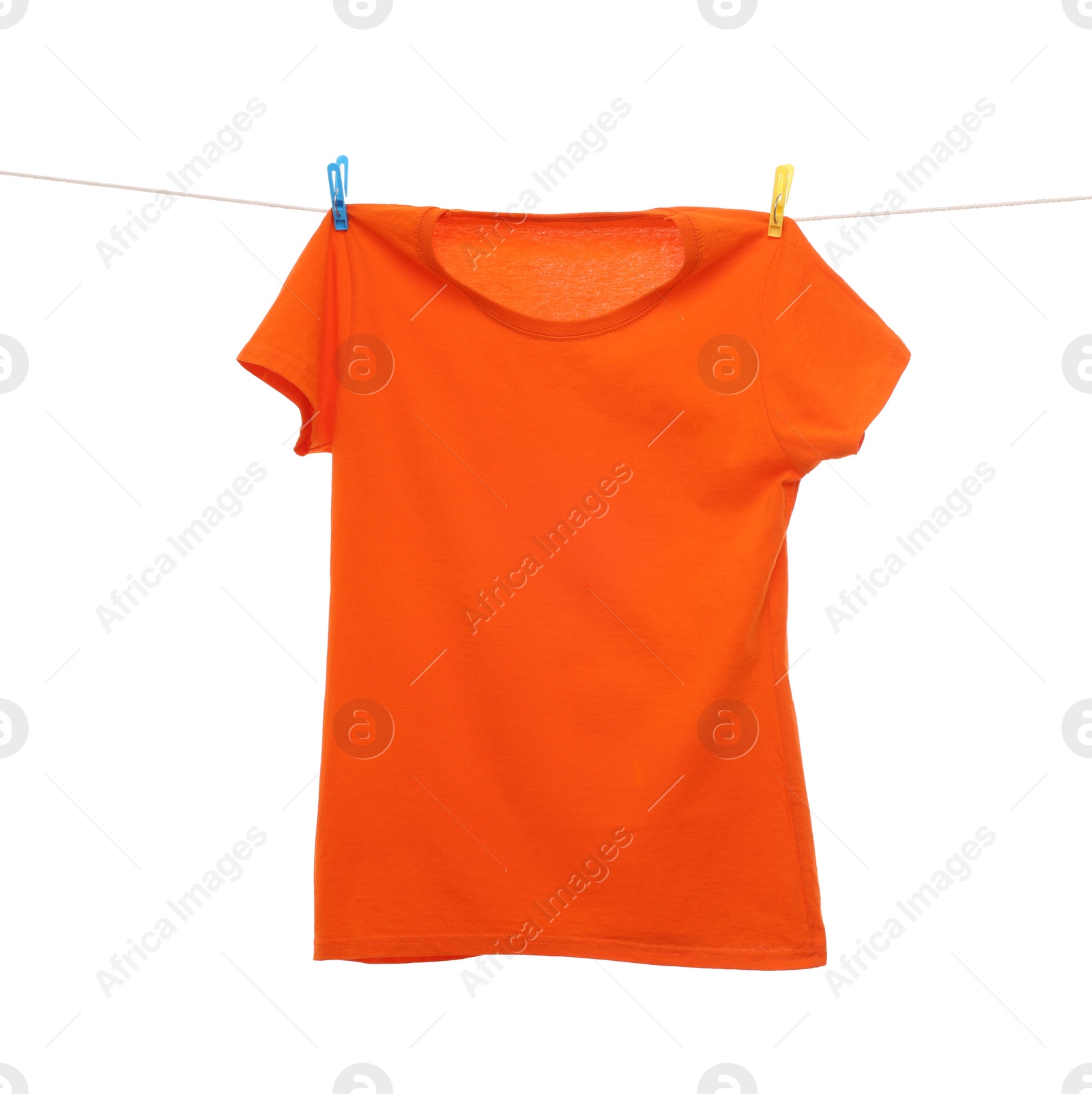 Photo of One orange t-shirt drying on washing line isolated on white