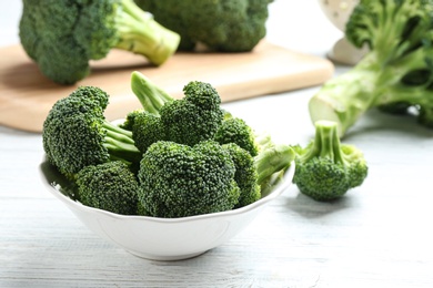 Photo of Plate of fresh green broccoli on white wooden table, closeup view. Space for text