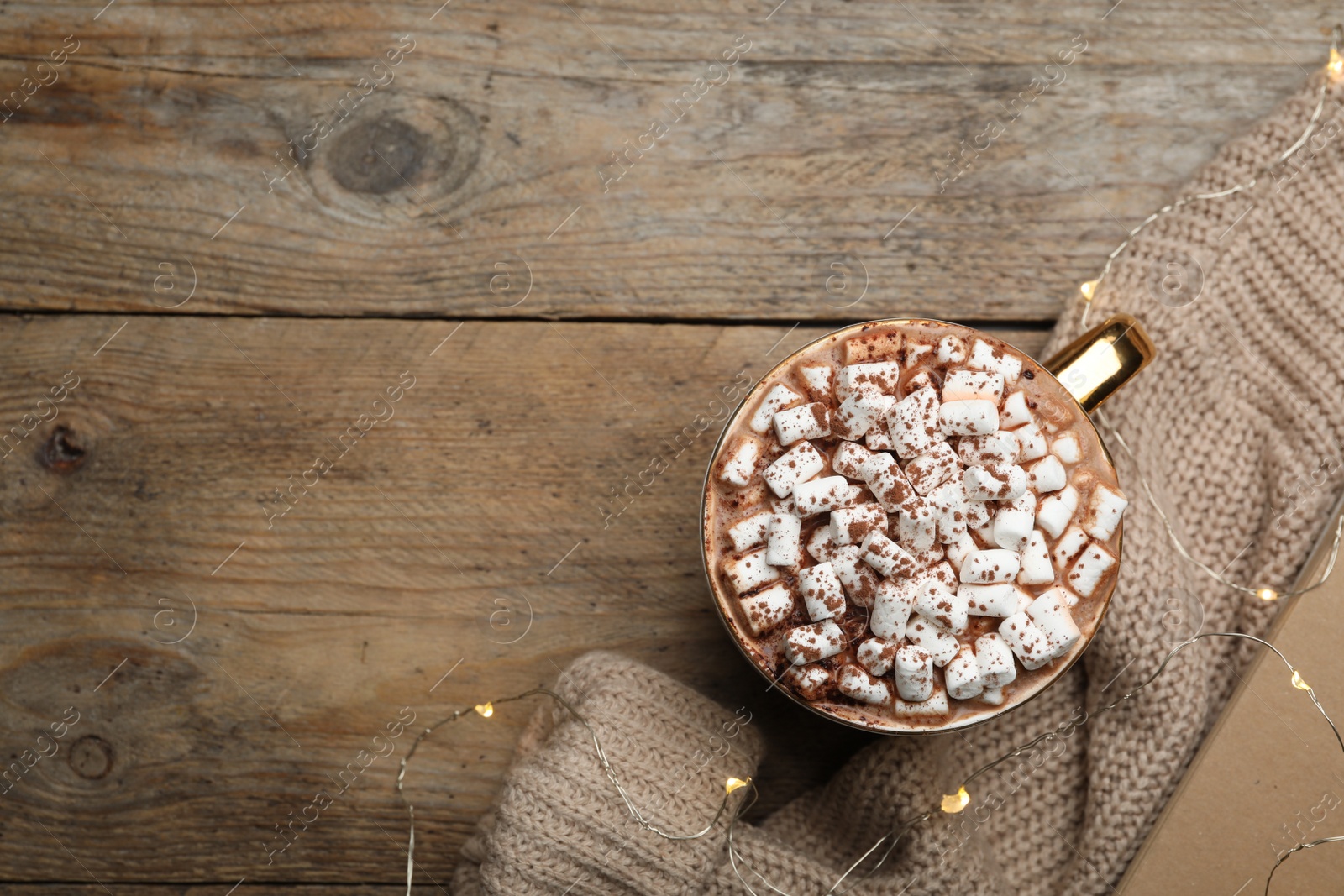 Photo of Cup of delicious hot cocoa with marshmallows on wooden table, flat lay. Space for text