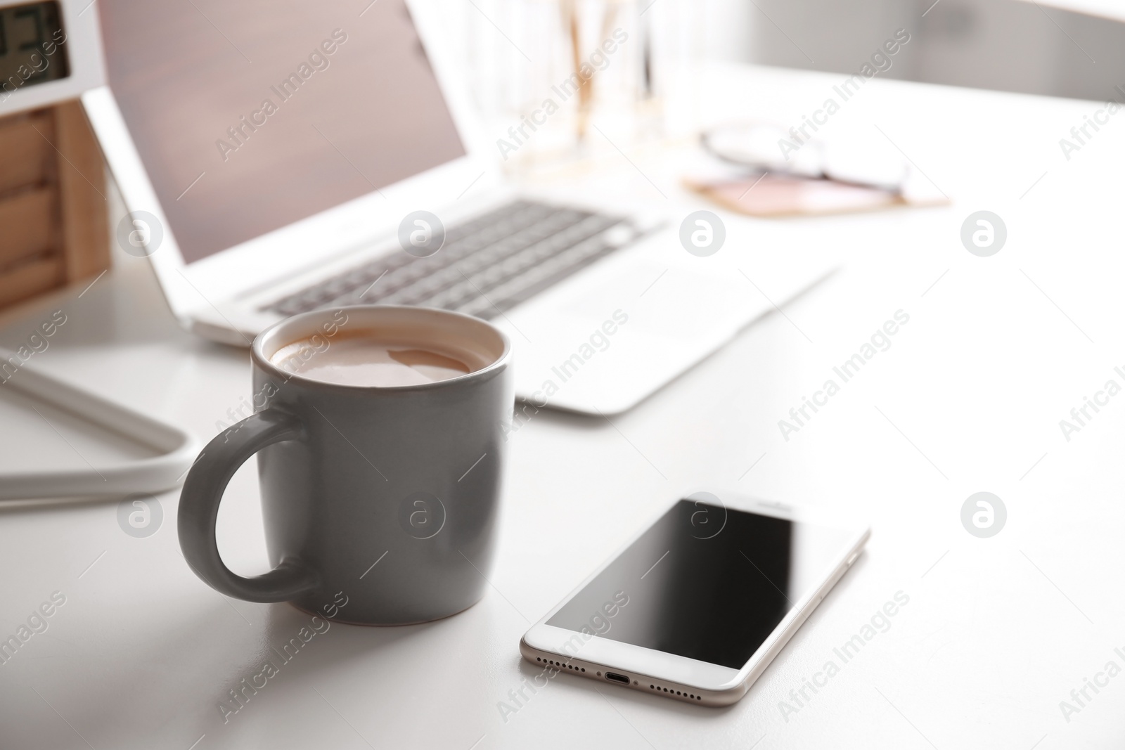 Photo of Coffee cup on table at modern workplace in office