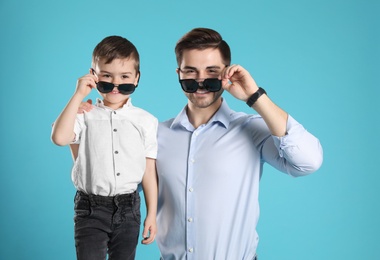 Portrait of dad and his son on color background