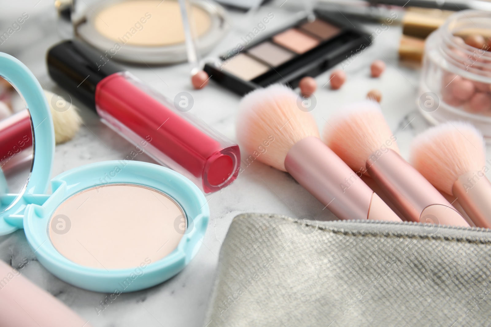 Photo of Different cosmetic products and makeup accessories on white marble table