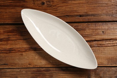 Photo of One ceramic plate on wooden table, top view