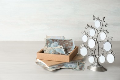 Photo of Family tree photo frame, pictures and notebook on light wooden table. Mockup for design
