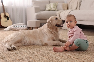 Photo of Cute little baby with adorable dog on floor at home