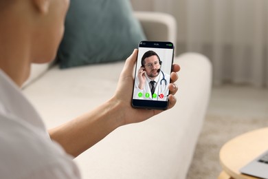 Online medical consultation. Man having video chat with doctor via smartphone at home, closeup