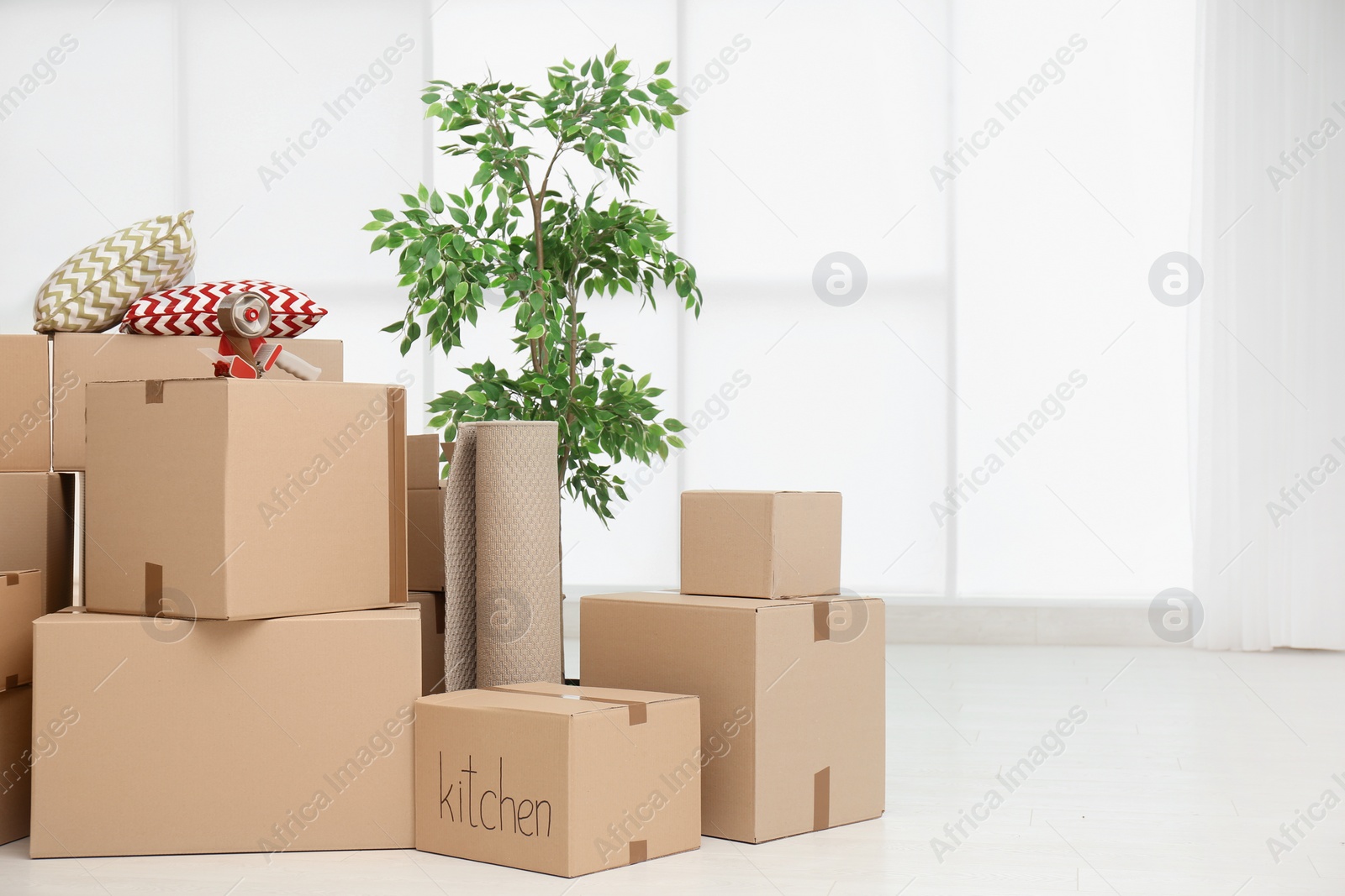 Photo of Pile of moving boxes in empty room