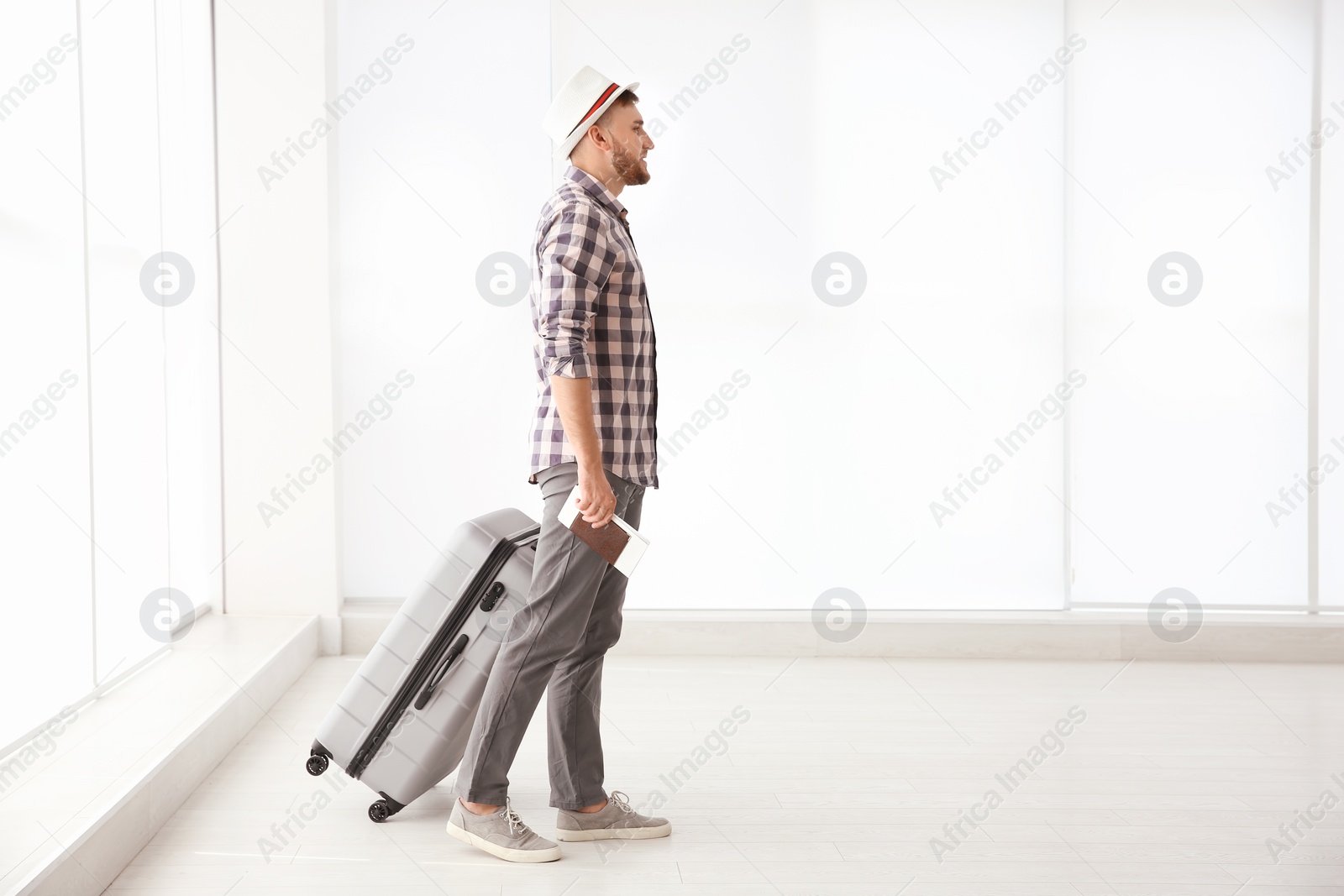 Photo of Young man with suitcase in airport