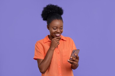 Photo of Beautiful young woman with smartphone on purple background