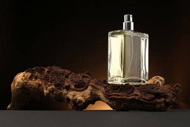 Luxury men`s perfume in bottle on grey table against dark background, space for text