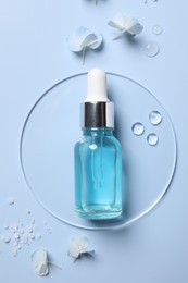 Photo of Bottle of cosmetic serum, flowers and sea salt on light blue background, flat lay