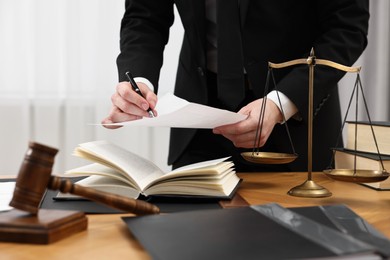 Lawyer working with document at wooden table, closeup