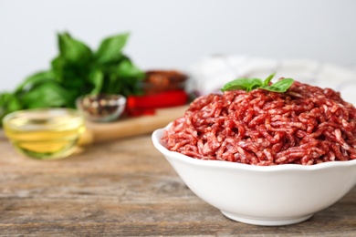 Photo of Fresh raw minced meat on wooden table, space for text