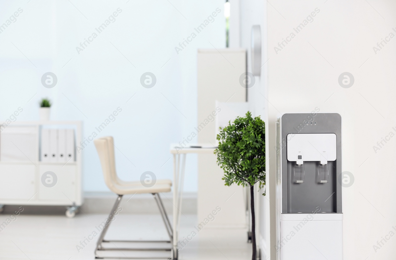 Photo of Modern water cooler in stylish office interior