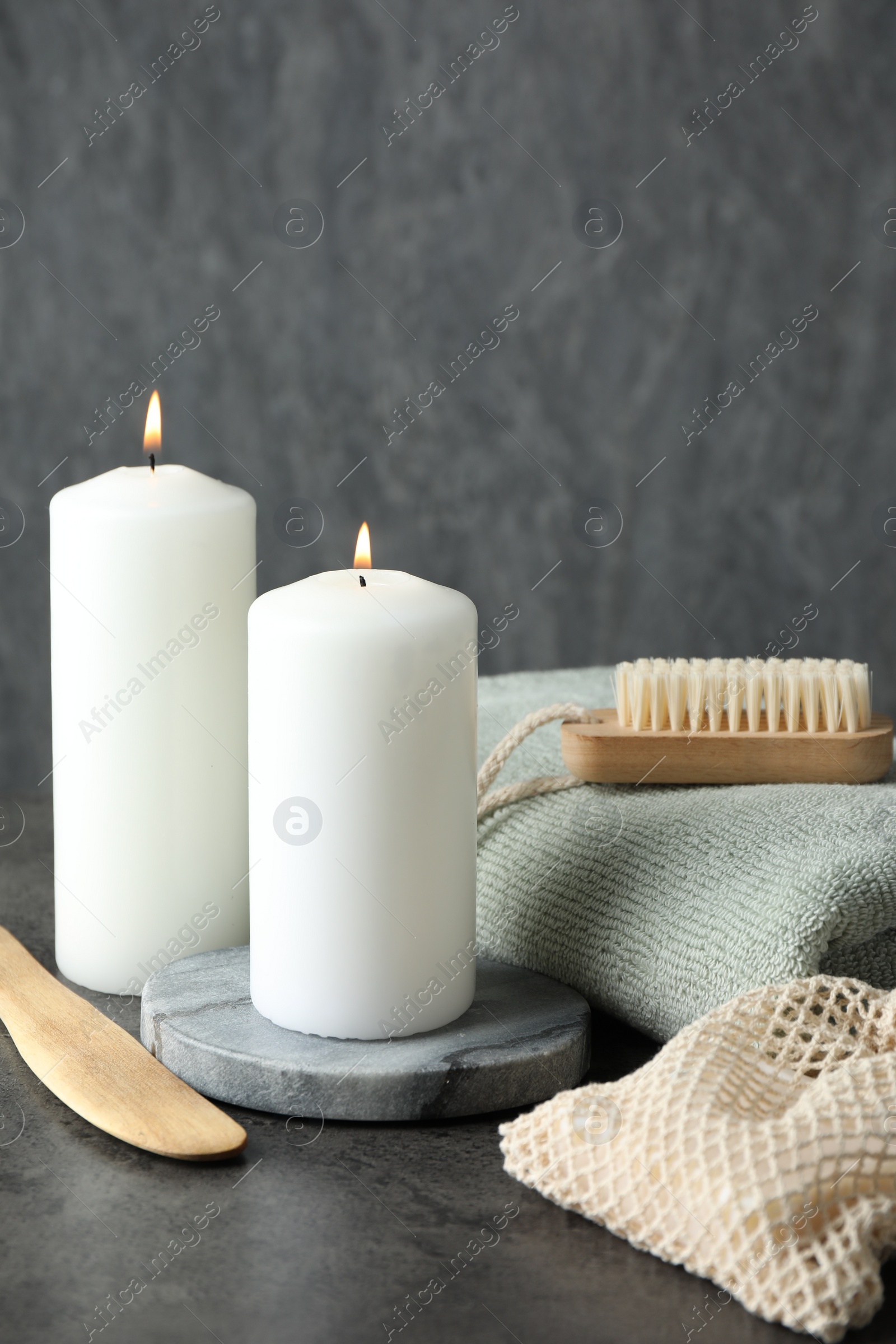 Photo of Composition with different spa products and burning candles on grey table