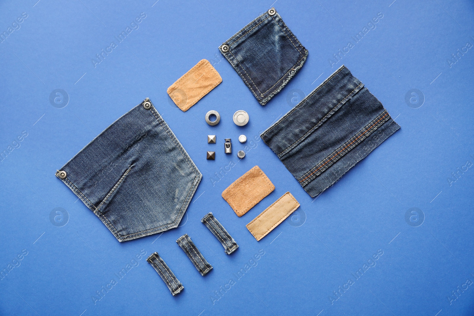 Photo of Flat lay composition with garment accessories and cutting details for jeans on blue background