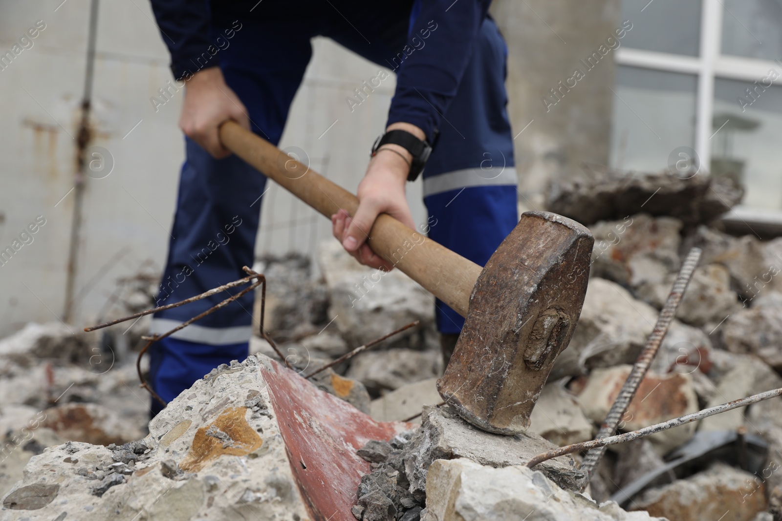 Photo of Man breaking stones with sledgehammer outdoors, selective focus