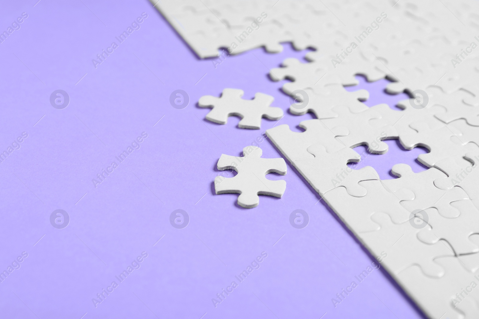 Photo of Blank white puzzle pieces on violet background