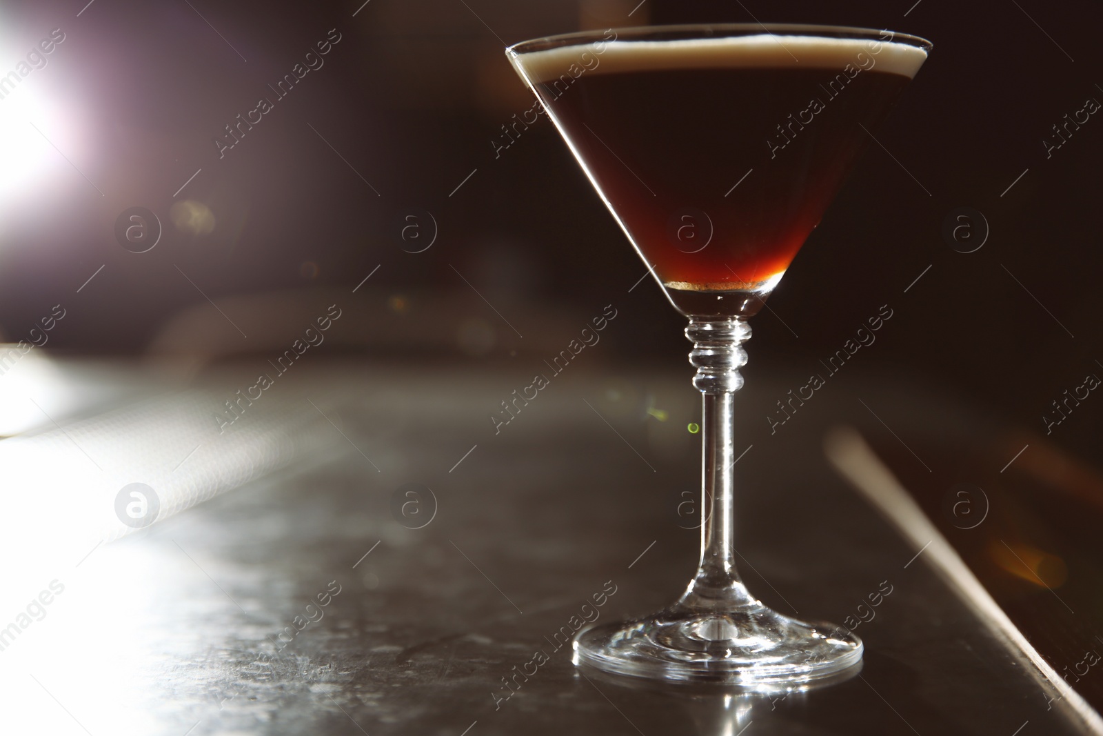 Photo of Glass of martini espresso cocktail on bar counter. Space for text