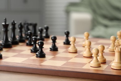 Photo of Chess board with pieces on wooden table, selective focus. Space for text