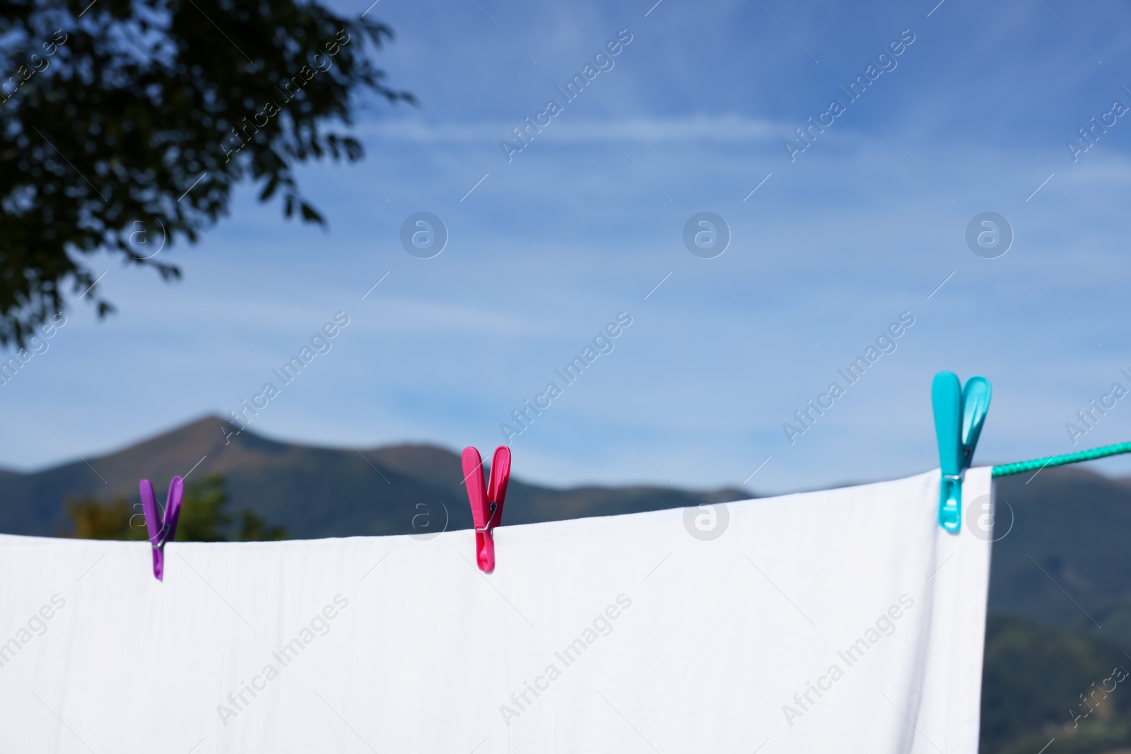 Photo of Laundry with clothes pins on line outdoors. Space for text