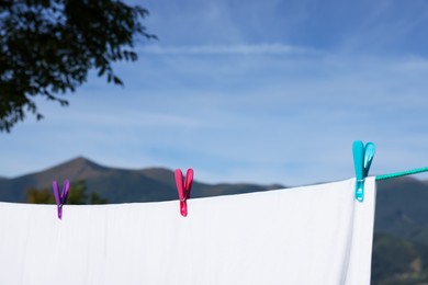 Laundry with clothes pins on line outdoors. Space for text