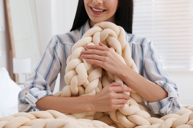 Photo of Woman with chunky knit blanket at home, closeup