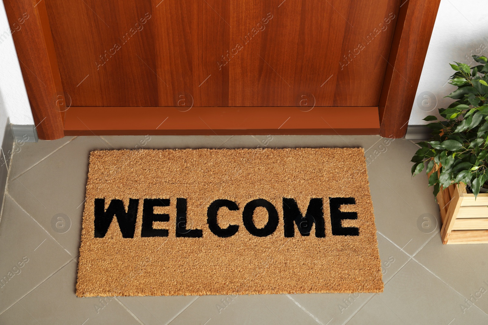 Photo of Door mat with word Welcome on floor near entrance, above view