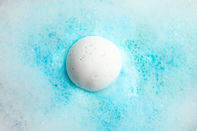 Photo of Color bath bomb dissolving in water, closeup