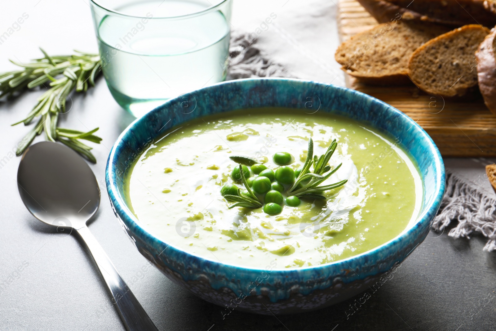 Photo of Fresh vegetable detox soup made of green peas in dish served on table