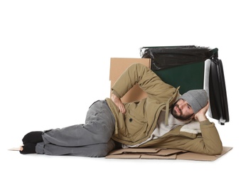 Poor homeless man lying near trash bin isolated on white