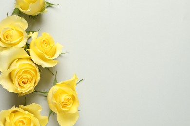 Photo of Beautiful yellow roses on light grey background, flat lay. Space for text