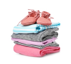 Photo of Children's shoes and stack of clothes on white background