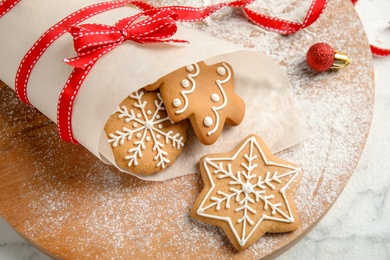 Photo of Tasty decorated Christmas cookies on wooden board, closeup