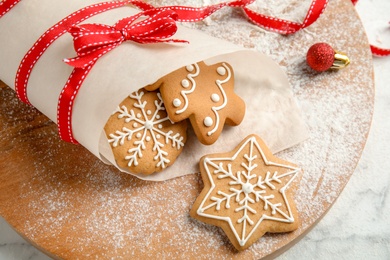 Tasty decorated Christmas cookies on wooden board, closeup