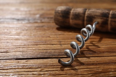 Photo of One corkscrew on wooden table, closeup. Space for text