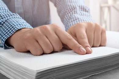 Photo of Blind person reading book written in Braille, closeup